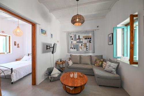a living room with a couch and a table at Tinos Traditional Patio House in Arnados