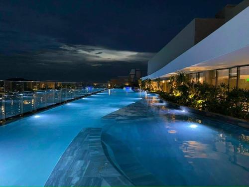 a large swimming pool at night on a building at The Song Luxury Vung Tau Apartment - QUỲNH's Homestay in Vung Tau