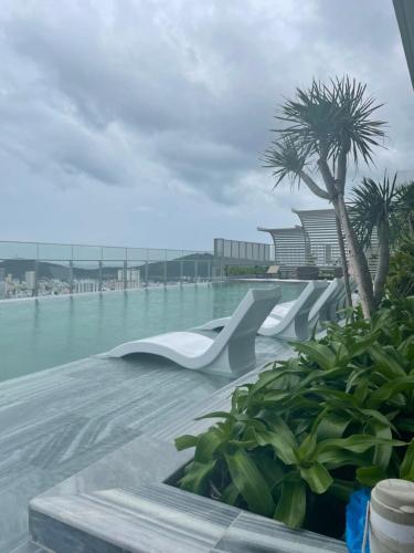 a view of a swimming pool with a palm tree at The Song Luxury Vung Tau Apartment - QUỲNH's Homestay in Vung Tau
