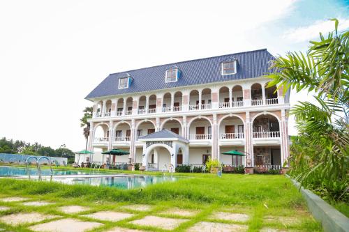 a large building with a pool in front of it at The Bheemili House in Bhīmunipatnam