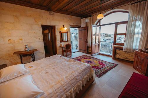 Un dormitorio con una cama grande y una ventana grande. en Mithra Cave Hotel, en Göreme