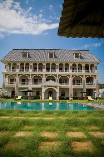 a large building with a pool in front of it at The Bheemili House in Bhīmunipatnam