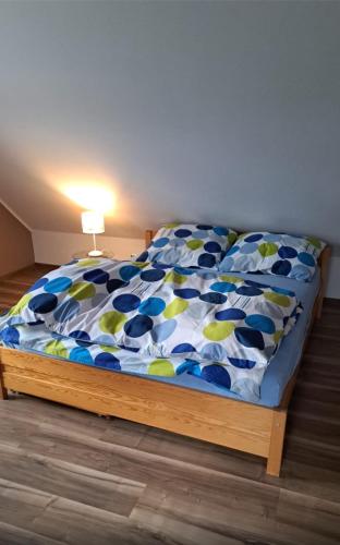 a bedroom with a bed with a blue and green comforter at Przytulny 