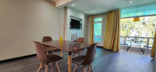 a dining room with a wooden table and chairs at Phoenix Beach Apartments sea view in Flic-en-Flac