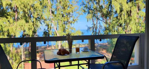 a table and chairs on a balcony with a view at Phoenix Beach Apartments sea view in Flic-en-Flac