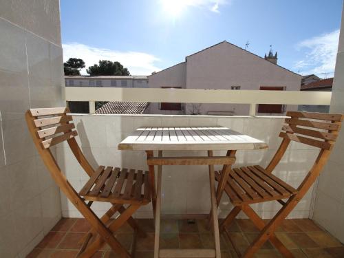 une table et deux chaises sur un balcon dans l'établissement Charmant T2 au cœur du village avec garage, balcon ensoleillé et wifi à Balaruc-les-Bains. - FR-1-553-183, à Balaruc-les-Bains