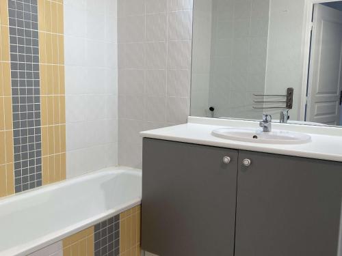 y baño con lavabo y bañera. en Appartement Balaruc-les-Bains, 2 pièces, 2 personnes - FR-1-553-214, en Balaruc-les-Bains