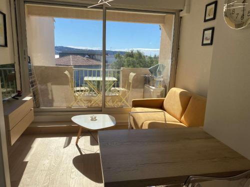 un salon avec un canapé et une grande fenêtre dans l'établissement T1 Mezzanine Climatisé avec Parking et Wifi à Balaruc-les-Bains - FR-1-553-215, à Balaruc-les-Bains