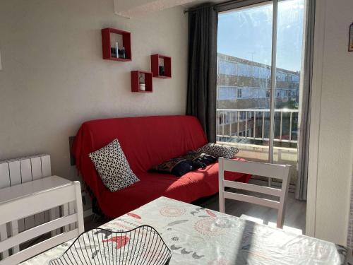 - un salon avec un canapé rouge et une fenêtre dans l'établissement Charmant T1 à Balaruc-les-Bains - 32m², ascenseur, WIFI, proche centre spa - FR-1-553-213, à Balaruc-les-Bains