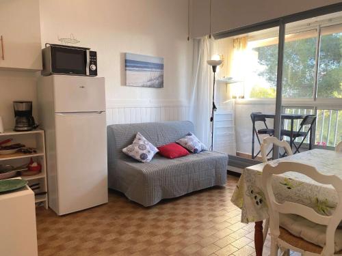 - un salon avec un réfrigérateur et un canapé avec des oreillers dans l'établissement Appartement T2 avec loggia et internet à deux pas de l'étang de Thau à Balaruc-les-Bains - FR-1-553-217, à Balaruc-les-Bains