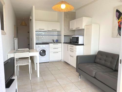 une cuisine avec un canapé et une table dans l'établissement T1 avec balcon, clim, wifi, animaux OK à Balaruc-les-Bains - FR-1-553-199, à Balaruc-les-Bains