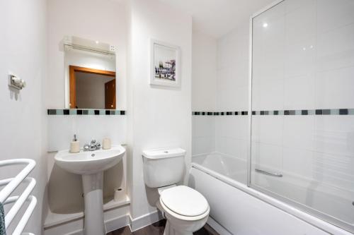 a white bathroom with a toilet and a sink at Modern Apartment Near Train Station in Ipswich