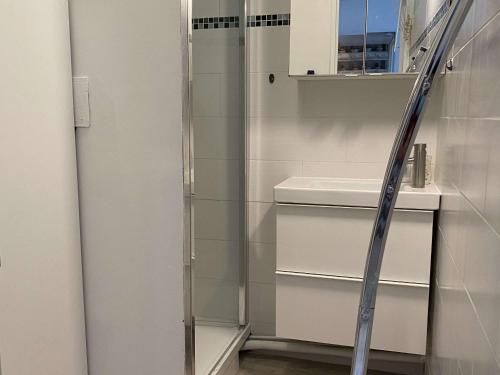 une douche avec une porte vitrée à côté d'un lavabo dans l'établissement Charmant T2 avec parking à Balaruc-les-Bains - FR-1-553-212, à Balaruc-les-Bains