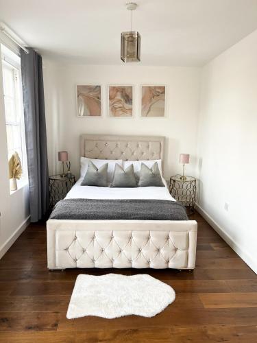 een witte slaapkamer met een groot bed met een wit matras bij London Stylish 1 Bedroom Apartment in Londen