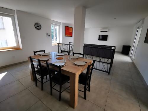 T3-Le Vimaine-Vienne في فيين: غرفة طعام مع طاولة وكراسي خشبية