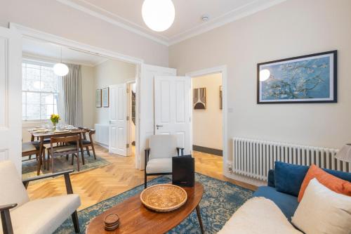 un soggiorno con divano e tavolo di Spacious Private home with King sized bed and Garden newly renovated a Londra