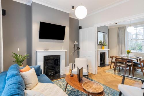 un soggiorno con divano blu e camino di Spacious Private home with King sized bed and Garden newly renovated a Londra