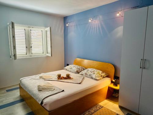 um quarto com uma cama com uma parede azul em Dubrovnik Apartments em Dubrovnik