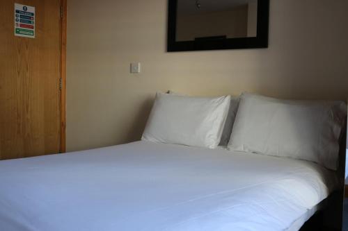 a bed with white sheets and pillows in a room at Lower Turks Head in Manchester