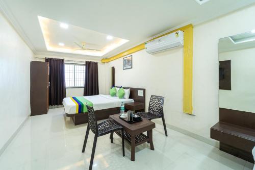 a hotel room with a bed and a table and chairs at Treebo Kaizen, 3 Kms From Paragliding in Panchgani