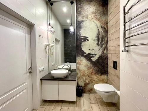 a bathroom with a painting of a woman on the wall at Central street in Kharkiv