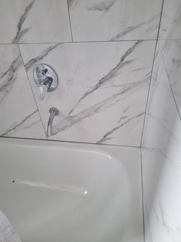 a shower in a bathroom with a marble counter top at Tu descanso en Coronel Suarez in Coronel Suárez