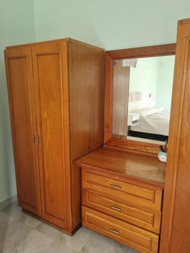 a wooden cabinet with a mirror and a dresser at Tu descanso en Coronel Suarez in Coronel Suárez