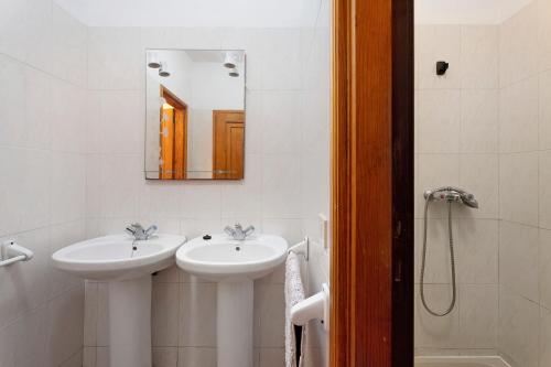 Baño blanco con 2 lavabos y espejo en Casa Epina, en Vallehermoso