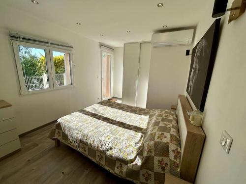 a bedroom with a bed and a window at Bas de villa cosy Juan les Pins avec jardin in Juan-les-Pins