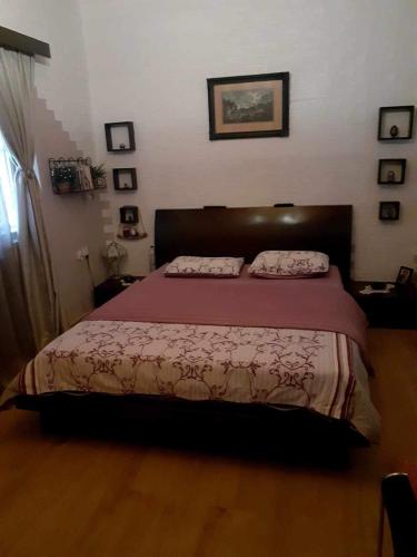 a bedroom with a large bed with a red bedspread at Sarah Delight in Pýrgos