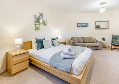 a bedroom with a large bed and a couch at The Corn Bin in Sedlescombe