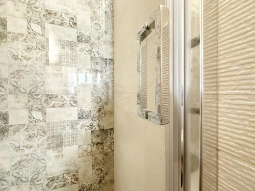 a bathroom with a door and a tile wall at Casa Marti Belfioreguesthouses in Pontedera