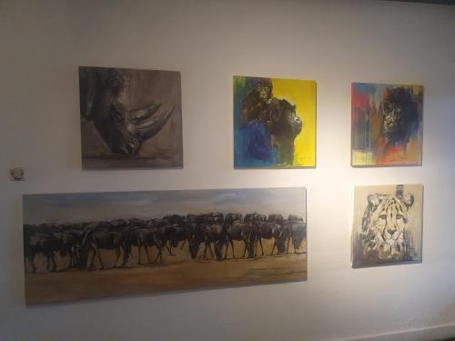 eine Gruppe von Gemälden an einer Wand in der Unterkunft S.A.W.A (Studio of African wildlife Arts) 