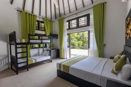 a bedroom with two bunk beds and a window at Indra Manel Family Holiday Resort Kandy in Kandy