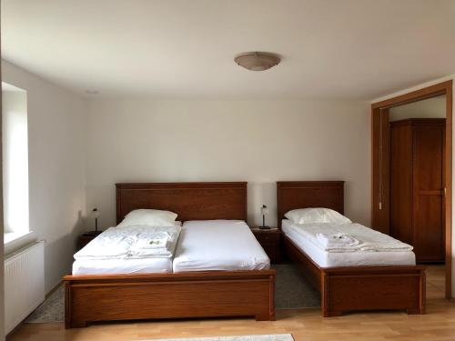 2 bedden in een kamer met 2 bedden, waarvan 1 tweepersoonsbed en 1 eenpersoonsbed. bij Vila u Urbana in Havířov