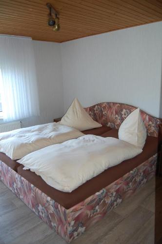 - un grand lit dans une chambre avec publicité lors d'une manifestation dans l'établissement Haus Resi, à Wiesmoor