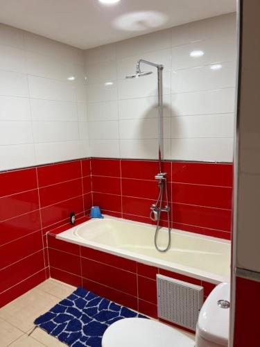 a red and white bathroom with a tub and a toilet at Maison Dar Zarka in Aghmat