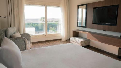 a hotel room with a bed and a television at Rivoli Suites and Spa in Hurghada