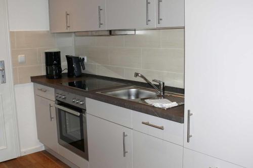 a small kitchen with a sink and a stove at Haus-Auetal in Bliedersdorf