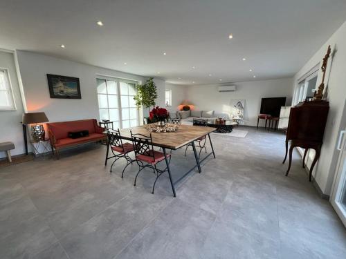 ein Wohnzimmer mit einem Tisch, Stühlen und einem Sofa in der Unterkunft Horse Lodge de Bélian in Hannut