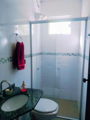 a bathroom with a shower and a toilet and a sink at SHOW RURAL 2024- casa com ar e piscina in Cascavel