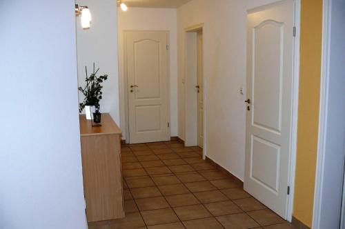 a hallway with two doors and a tiled floor at Haus-Auetal in Bliedersdorf