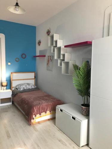 - une chambre avec un lit et un mur bleu dans l'établissement River City Apartments, à Rijeka