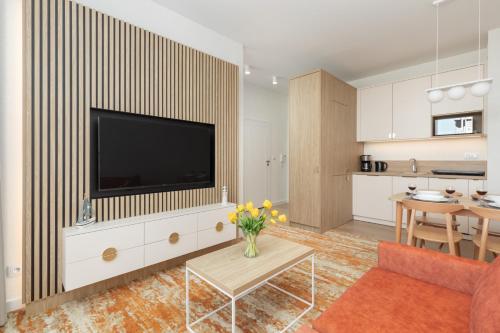 a living room with a flat screen tv on a wall at Bel Mare Modern Apartment with Balcony by Renters in Międzyzdroje