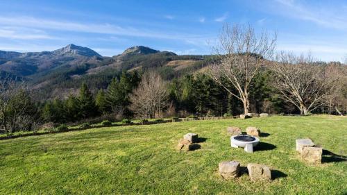 a bench in a field with mountains in the background at Soloandie Casa rural in Zeanuri