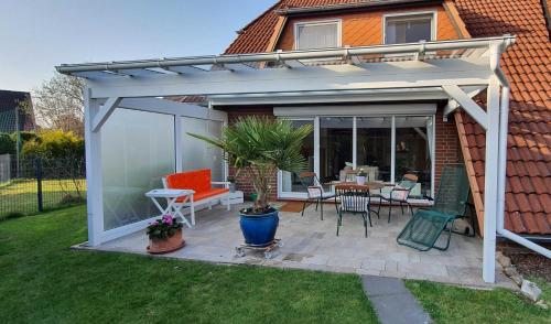a pergola with a table and chairs on a patio at Sonnenkoje in Apensen