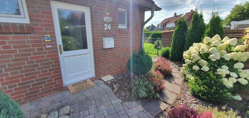 a brick house with a welcome sign in front of a door at Sonnenkoje in Apensen