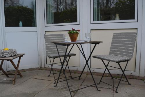 two chairs and a table with a plant on a porch at Kiek mol in in Ottensen
