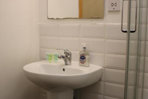 a bathroom sink with a bottle of soap on it at Lower Turks Head in Manchester