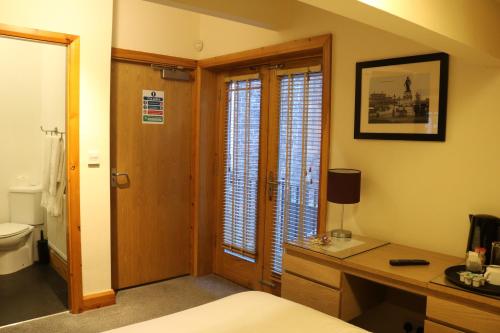 1 dormitorio con cama, escritorio y aseo en Lower Turks Head en Mánchester